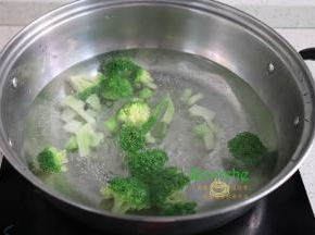 煮锅再次倒入适量的水煮沸之后，倒入切好的西兰花，汆烫熟，捞出过冷水，过冷水可以让西兰花颜色翠绿，爽口好吃。
