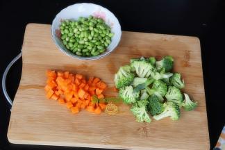 西兰花洗净切小朵，胡萝卜去皮洗净切粒，毛豆用清水洗净沥干水。其中胡萝卜、西兰花不需要太多，毛豆、西兰花、胡萝卜比例为1:1:1。