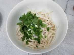 把小葱和香菜段放入海鲜菇碗中