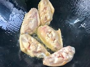 起锅热油，放入鸡翅，皮面朝下
