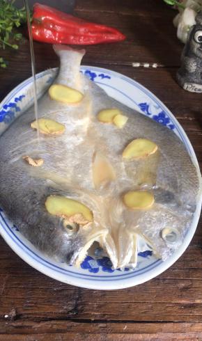 把姜片均匀的放在鱼身上，淋入白酒