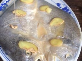 把姜片均匀的放在鱼身上，淋入白酒