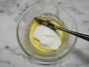 用刮刀把1/3打发好的蛋白霜倒入蛋黄糊里，从底部向上翻拌并切拌均匀