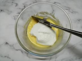 用刮刀把1/3打发好的蛋白霜倒入蛋黄糊里，从底部向上翻拌并切拌均匀