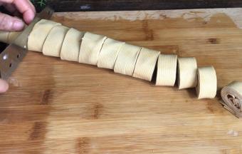 把浸泡好的千张叠在一起，卷成卷，切成小段