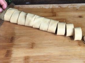 把浸泡好的千张叠在一起，卷成卷，切成小段