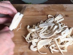 把浸泡好的千张捞出，切成丝