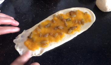 撒上葡萄干，把一头的边缘按成薄皮