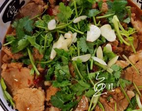 肉片上放香菜段和大蒜片