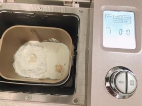 把所有材料都先称好，然后除了黄油之外，将所有的材料都投进面包机启动和面功能和面功能是10分钟，揉完一个程序就能达到初步扩展