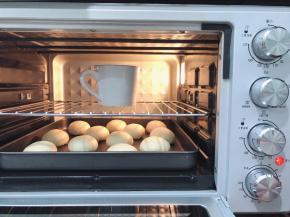 将包好馅儿的面胚收口朝下，摆放在烤盘中，放进烤箱内发酵至1.5倍大，手指粘面粉在面团上轻摁表面可缓慢回弹就可以了