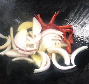 就着油锅，放入洋葱丝和红椒丝，炒匀