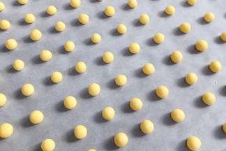 分成若干个小剂子，挨个搓圆放入垫有油纸的烤盘上，比黄豆粒稍微大一点，约1～2克均可。