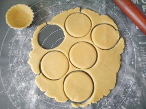 取出面团，底部撒适量面粉防粘，面团表面盖一层油纸，擀成3厘米厚的面片，压出比蛋挞模具稍大的面片。