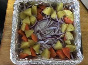 烤盘垫锡纸，放入洋葱丝 ，再放好土豆和胡萝卜，