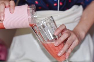 将榨好的果汁倒进杯中。