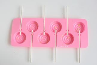 煮好的糖浆震几下消掉大气泡，倒入棒棒糖模具内。