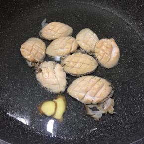 锅里倒入2碗清水，加入姜片，倒入鲍鱼焯水。