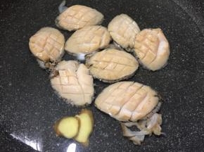 锅里倒入2碗清水，加入姜片，倒入鲍鱼焯水。