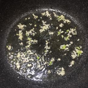 锅里加入适量食用油，放入蒜末和葱白煸出香味。
