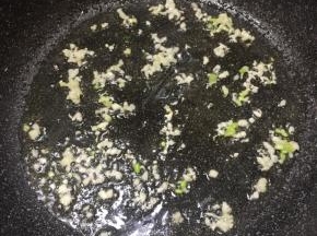 锅里加入适量食用油，放入蒜末和葱白煸出香味。