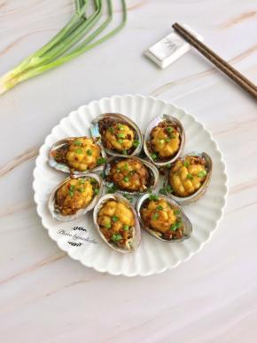 鲍鱼肉装入壳中，撒上葱花点缀，即可上桌享用。