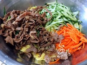 面条盆中放入牛肉丝、胡萝卜丝、黄瓜丝