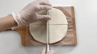 印度飞饼拿出冰箱撕去面上的塑料膜，稍微放置一会儿，但是不要解冻太久，以免太粘。在飞饼上切“十”字刀，把每块飞饼平均分成4份。