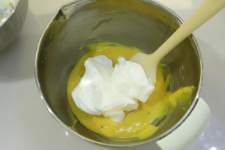 先取三分之一的蛋白加入到蛋黄糊内，翻拌手法拌匀。