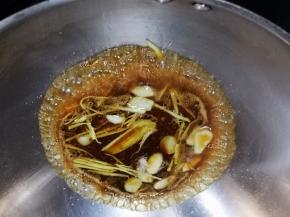 将方才准备的汤汁倒入，然后放入葱段和香菜炒片刻浇到另一半的鱼块上。