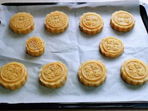 依次做完，放在垫有油纸的烤盘中，并间隔距离，再用喷壶喷点水在月饼胚上，避免高温烘烤开裂。