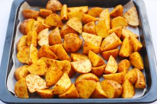 处理好的土豆放入铺好油纸的烤盘中。