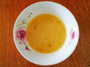 鸡蛋磕入碗中，加少许盐和料酒打散。