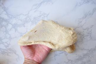 用手或者面包机厨师机把面团揉出厚膜后，加入黄油，黄油要提前从冰箱取出软化。直到把面团揉到能拉出筋膜。全麦的筋膜的延展性要比普通面团的略差一些，大家注意不要揉过头。