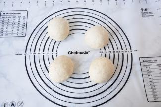 将发酵好的面团轻压排气，均分成四份，滚圆，盖保鲜膜松驰20分钟。这个过程，面团不要过度搓揉，否则会影响面包的口感。