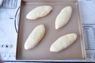 翻过来整理一下成鱼雷形，放在温暖处发酵，最佳温度为35-38度即可。室温低时，可以在烤箱的底部放热水加速发酵。