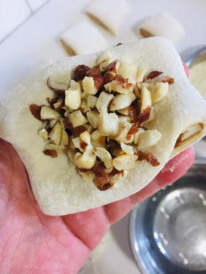 取一块儿面团按扁，放入适量的熟花生碎。