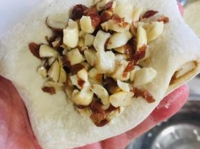 取一块儿面团按扁，放入适量的熟花生碎。