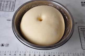 我用的是金龙鱼家用原味蛋糕粉，它采用100％进口小麦，属于低筋面粉，可以制作蛋糕，饼干，曲奇等等美味。这个面团不会象高筋面粉那样揉出筋膜有。看到它光滑了即可。将揉好的面团放入容器盖严实，放入冰箱冷藏发酵，经过一夜的低温发酵，面团口感更好。冷藏室的温度不要太低，度建议在5-7度左右。这是10个小时后的状态，约两倍大。您也可以揉好后先在室温中发酵一会，再放进冰箱。