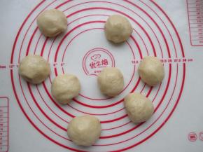 将发酵好的面团取出，轻压排气，再滚圆，然后分成8个小面团。