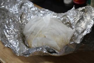 将腌制好的童子鸡先用厨房料理纸（油纸）裹好，再用铝箔纸裹上，我裹了2层铝箔纸，这样更严实些。
裹一层油纸是避免童子鸡在炸时候流出的汁水和铝箔纸粘在一起，破坏童子鸡的品相。