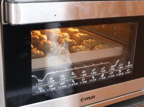 将全部印好的月饼连带烤盘，送入预热好的烤箱，上下火190℃，中层，烘烤5分钟，让月饼花纹定型。