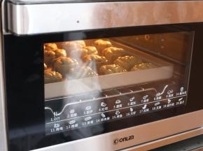 将全部印好的月饼连带烤盘，送入预热好的烤箱，上下火190℃，中层，烘烤5分钟，让月饼花纹定型。