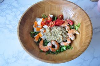 将煮熟的虾剥壳取肉，蟹足棒切段，西红柿切小块，并把藜麦放在盆中。