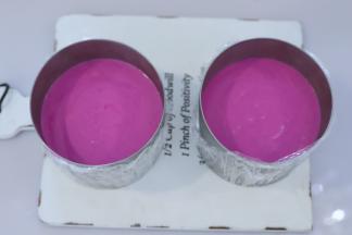 将做好的火龙果慕斯液分别倒入两个慕斯圈内，冰箱冷藏过夜。