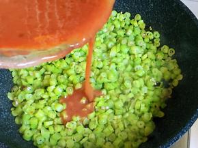 四季豆炒至透明状，浇上虾酱鸡蛋液，一面定型后再翻面。