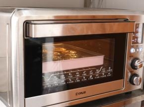 将全部印好的月饼连带烤盘，送入预热好的东菱烤箱，上下火190℃，中层，烘烤5分钟，让月饼花纹定型。