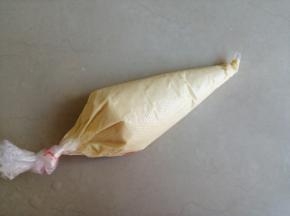 把面糊倒入裱花袋里，扎紧袋口，再用剪刀剪一个小小的口子。切记！一定要小口，口太大的话，挤出来的面糊就粗线条，不好看的。记得我第一次做的时候，就因为袋口剪大了，出来的效果一点也不好看