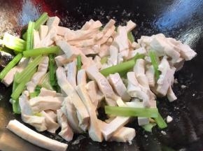 倒入芹菜和香干，翻炒均匀