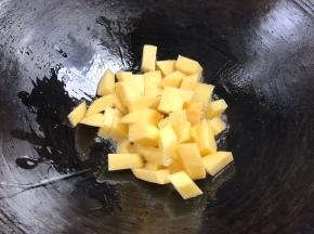 倒入土豆丁，煎炒至表面微黄